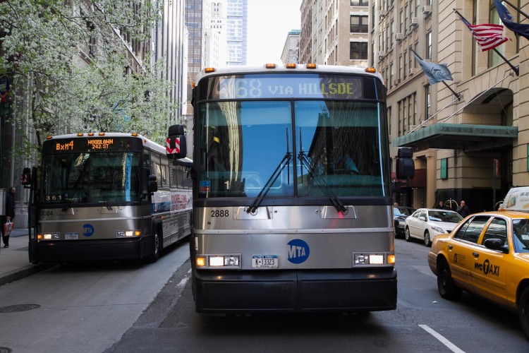 Two MTA buses are seen on Fifth Avenue in Midtown Manhattan, March 26. The MTA is planning to install additional video cameras on buses in order to help prevent criminal activity. (Benjamin Chasteen/The Epoch Times) 