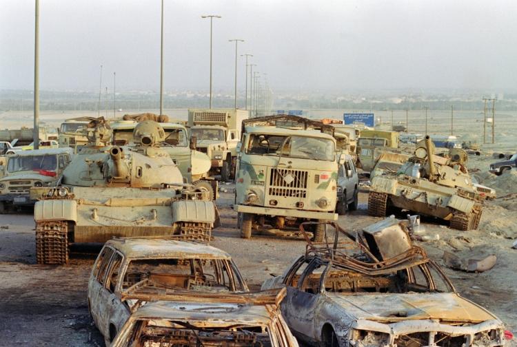TRAIL OF DESTRUCTION: A long line of vehicles, including destroyed Iraqi Army Russian-made T-62 tanks and trucks stand abandoned by fleeing Iraqi troops on the outskirts of Kuwait City March 1, 1991. Iraq's invasion of Kuwait on Aug. 2, 1990, led to the Gulf War, which began Jan. 16, 1991.(Pascal Guyot/Getty Images )