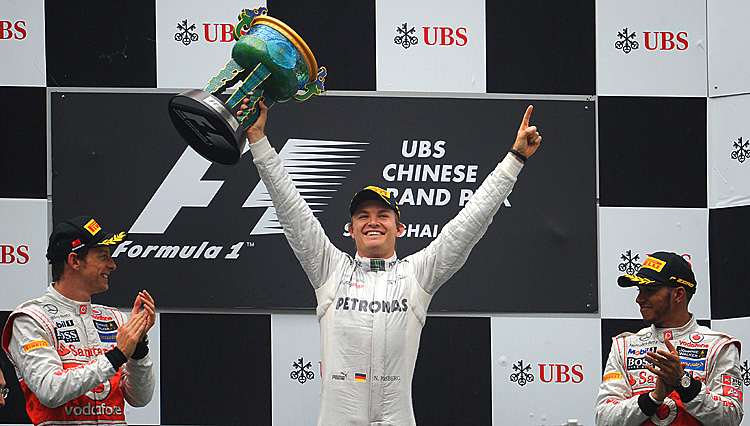 Mercedes-AMG driver Nico Rosberg celebrates his first Formula One win, the Chinese Grand Prix, while McLaren drivers Jenson Button (L) and Lewis Hamilton (R) look on. (Liu Jin/AFP/Getty Images)