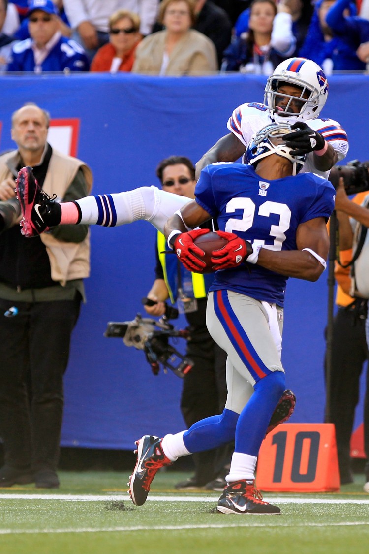 Corey Webster (23) is able to hang on, despite Bills' receiver Steve JohNson's facemasking, for his second interception of the day. The play changed the momentum as instead of giving up an almost-certain score New York drove down for the game-winning field goal. (Chris Trotman/Getty Images)
