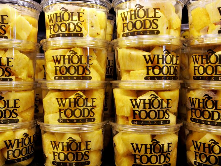WHOLESOME? Containers of fresh pineapple sit on display at a Whole Foods Market in San Francisco. Whole Foods announced solid fiscal third-quarter earnings and is planning a return to its 'healthy food market' roots.