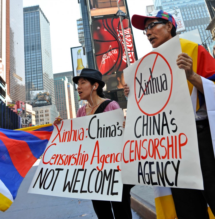 Students for a Free Tibet protest below a new electronic billboard leased by Xinhua (2nd from top), the Chinese regime's propaganda agency, as it makes its debut Aug. 1 in New York's Times Square. The LED sign is part of a strategy by the regime to make Xinhua more influential in American society. (Stan Honda/AFP/Getty Images)