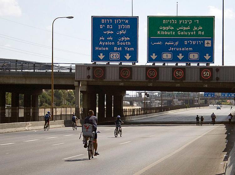 HOLIDAY: Bicyclists ride on the Ayalon Highway in Tel Aviv—one of the busiest roads in Israel—on Yom Kippur. Almost all public vehicular traffic stops until the holiday ends at sunset. (Genevieve Long/The Epoch Times)