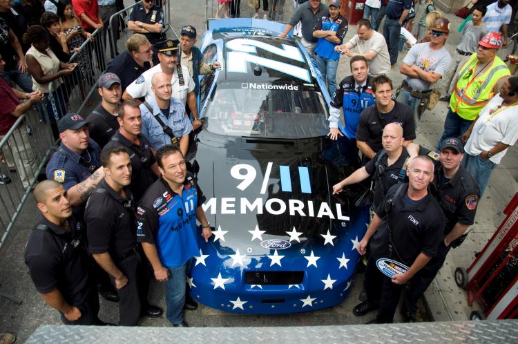 REMEMBER THIS: Both wearing 9/11 memorial shirts, NASCAR driver Benny Gordon (L Front), 9/11 Memorial President Joe Daniel (R Middle), and other launch the 9/11 race car near Ground Zero.  (Aloysio Santos/The Epoch Times)