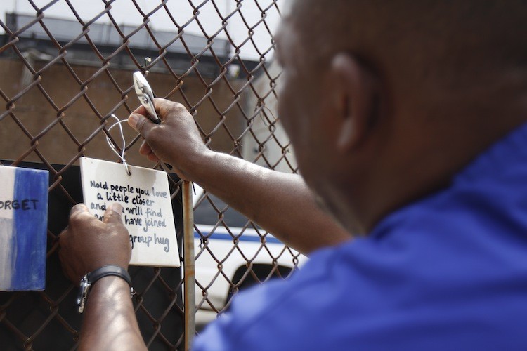 TILES TO REMEMBER: Henry Oliver puts up one of the tiles that are part of the Tiles for America memorial on West 11th Street and Seventh Avenue on Sunday. The tiles were removed for safekeeping shortly before Hurricane Irene.  (Ivan Pentchoukov/The Epoch Times)