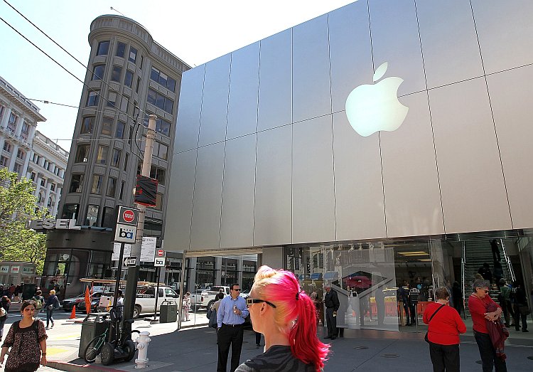 Pedestrians walk by an Apple Store