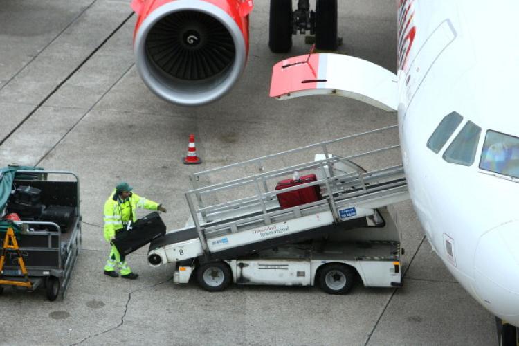 An airport employee pushes luggage into a plane of German airline Air Berlin at Duesseldorf International Airport on November 18, 2010 in Duesseldorf, western Germany.  (Patrik Stollarz/AFP/Getty Images)