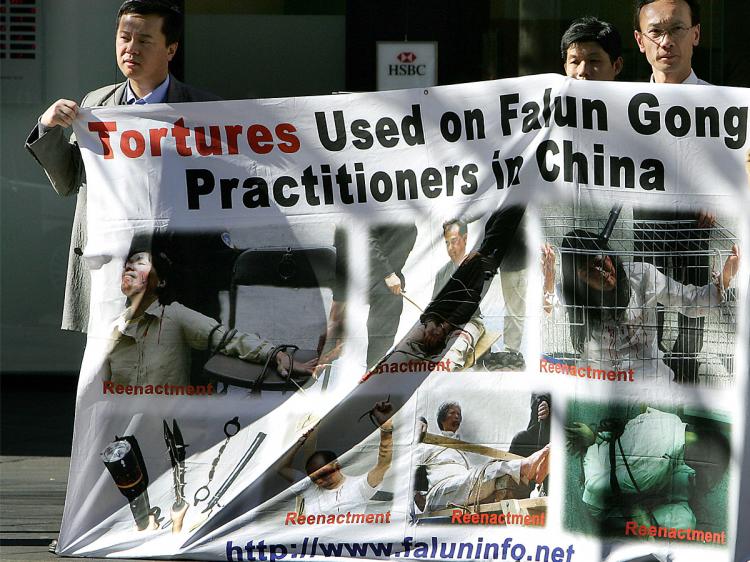 Supporters of Falun Gong display a banner near Chinatown in Sydney showing tortures used by the Chinese regime.   (Greg Wood/AFP/Getty Images)