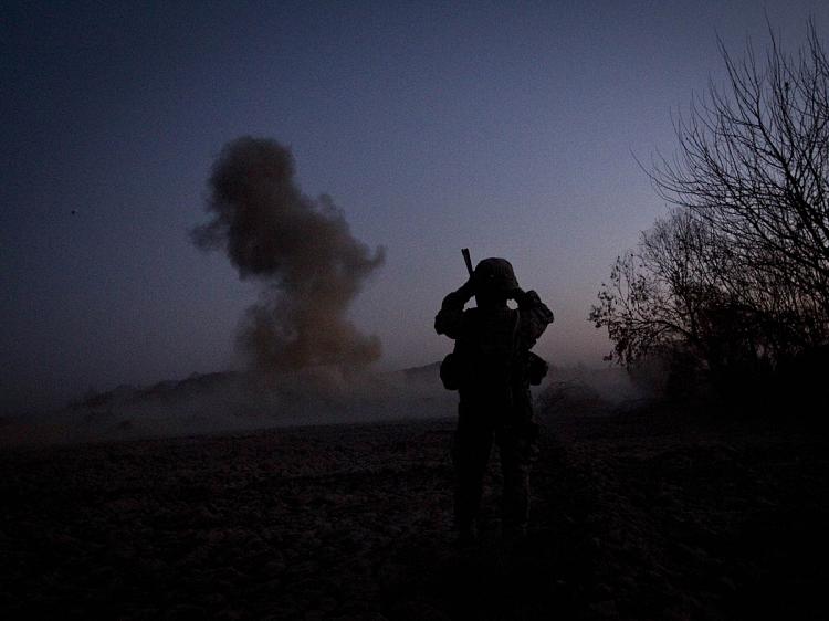 A U.S. soldier from Bravo Troop 1-75 Cavalry 2nd Brigade 101st Airborne Division records video footage while blowing up an Improvised Explosive device (IED) in Zari district of Kandahar province on December 29, 2010. (Behrouz Mehri/AFP/Getty Images)