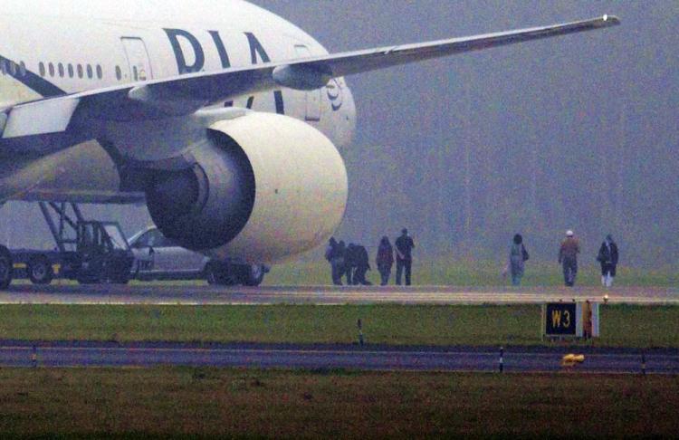 Two anti-terrorist policemen (C) secure one of the passengers as a Pakistan International Airlines Boeing 777 is evacuated at Stockholm Arlanda International airport on September 25, 2010. (Fredrik Persson/AFP/Getty Images)