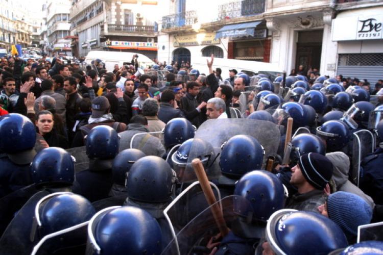 Demonstrators face riot police outside the opposition Rally for Culture and Democracy (RCD) party's headquarters in Algiers on Jan. 22. (STR/AFP/Getty Images)