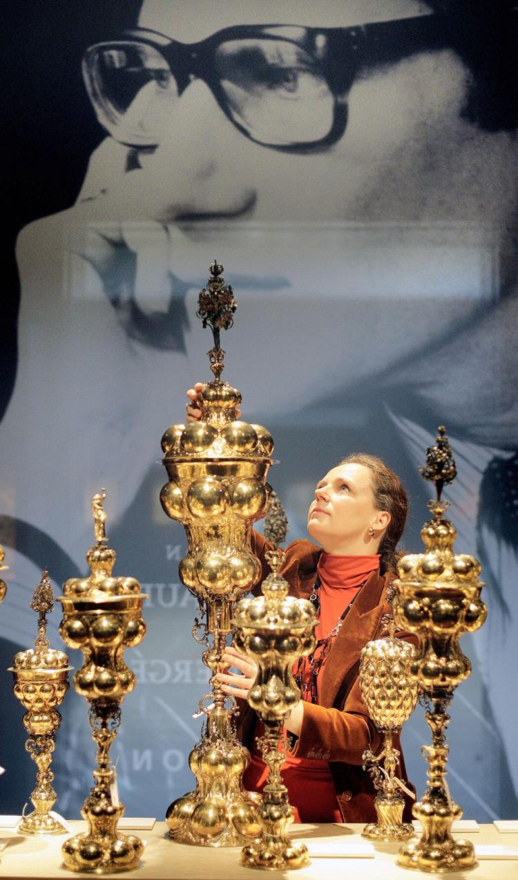 A Christie's employee poses with a a German parcel-gilt table fountain during a tour of an exhibition of 'The Collection of Yves Saint Laurent and Pierre Berge' at Christie's auction house in central London, on Jan. 29, 2009. (Shaun Curry/AFP/Getty Images)