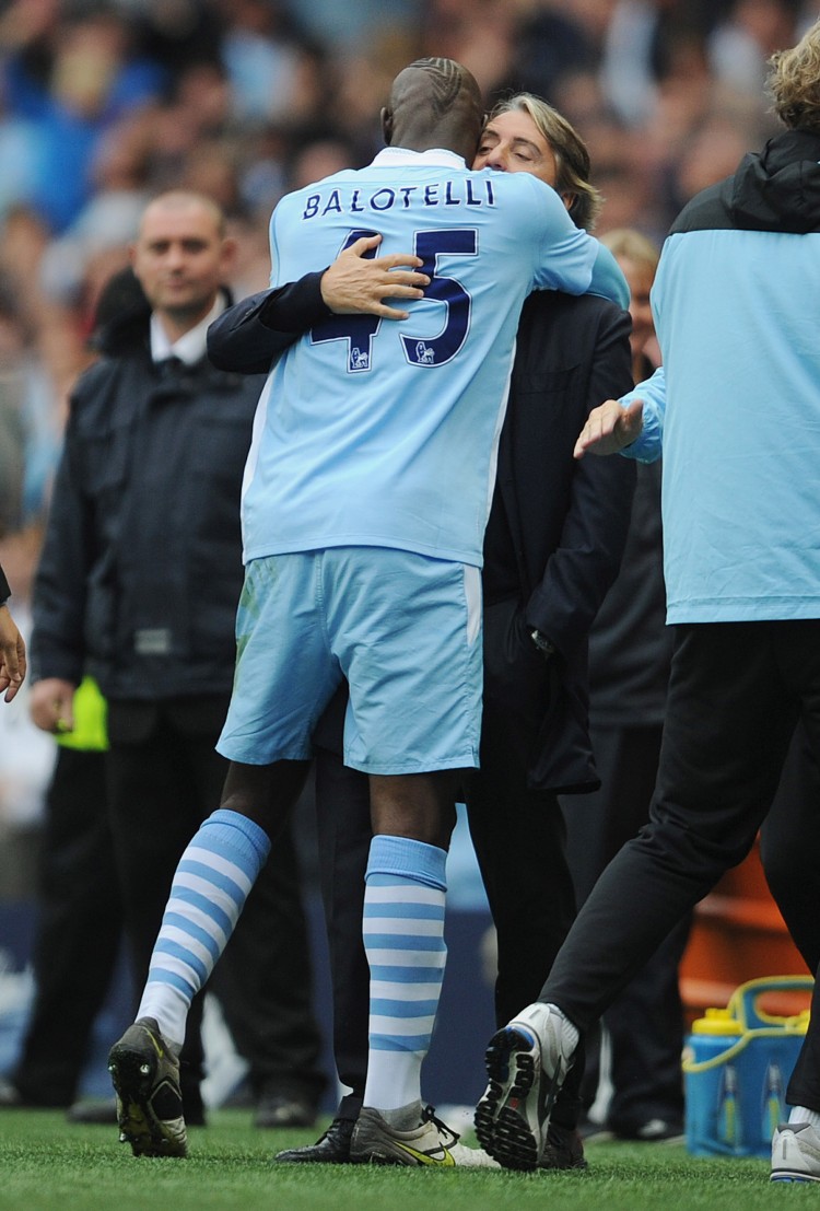 Manchester City striker Mario Balotelli hugs manager Roberto Mancini after scoring the winning goal against Everton on Saturday. (Michael Regan/Getty Images)