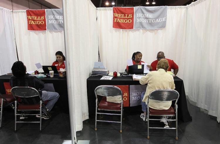 Wells Fargo employees help homeowners go over paperwork during a free workshop for customers who are facing mortgage payment challenges April 26, at the Oakland Convention Center in Oakland, California.  (Justin Sullivan/Getty Images)