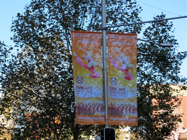 Banners fluttering high above a busy city street.
