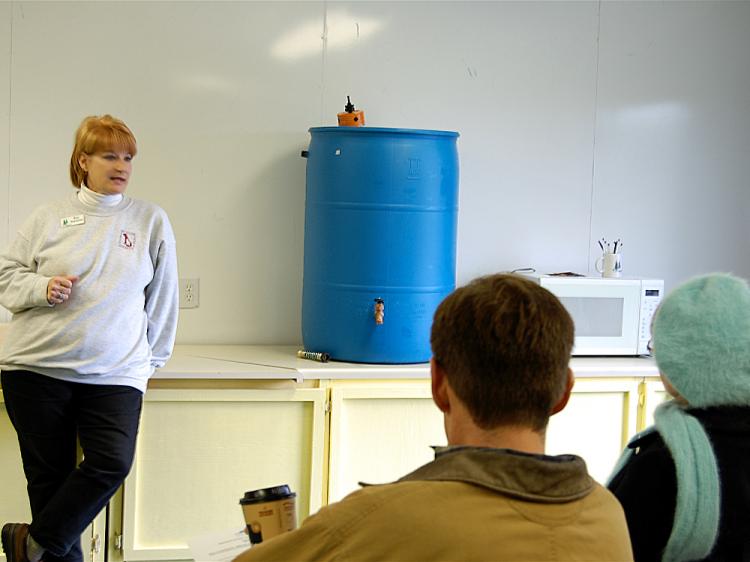 Kat Stratton shows her North Georgia class a rain barrel.  (Mary Silver/The Epoch Times)