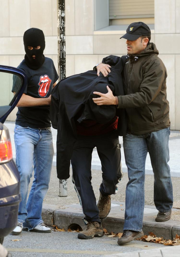 An unidentified person (C), suspected of being a member of Segi, an outlawed youth group believed to have ties to the armed Basque separatist group ETA, is escorted to a police car on November 24, 2009, in the northern Spanish Basque city of San Sebastian. (Rafa Rivas/Getty Images)