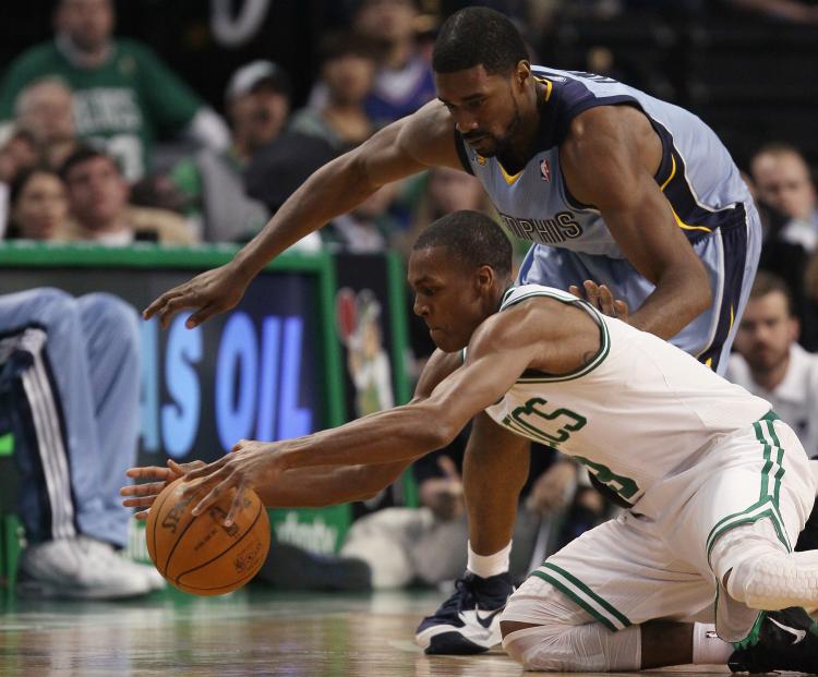 Rajon Rondo of the Boston Celtics and Leon Powe of the Memphis Grizzlies go after the ball in Wednesday night's game in Boston.  (Elsa/Getty Images )