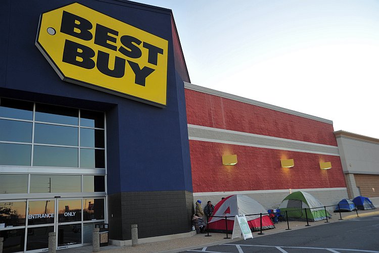 Patrons stand in line in front of a Best Buy store