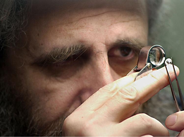 An unidentified diamond trader examines a newly polished stone at the Diamond Market in Antwerp, Belgium. (Paul O'Driscoll/Getty Images)