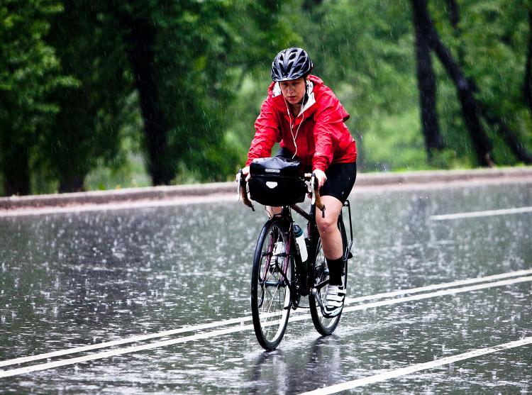 A wet bicycle rider in Central Park on Wednesday. After recent disputes between the NYPD, cyclists the Parks dept. an amicable policy has been put in place.  (Amal Chen/The epoch Times)