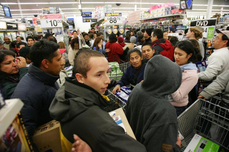 Black Friday ads are coming out just as stores are being warned by the government to control their crowds for the shopping blitz. Above, shoppers try to work their way through the crowd that mobbed the Wal-Mart on Black Friday in 2005. (ROBYN BECK/AFP/Getty Images)