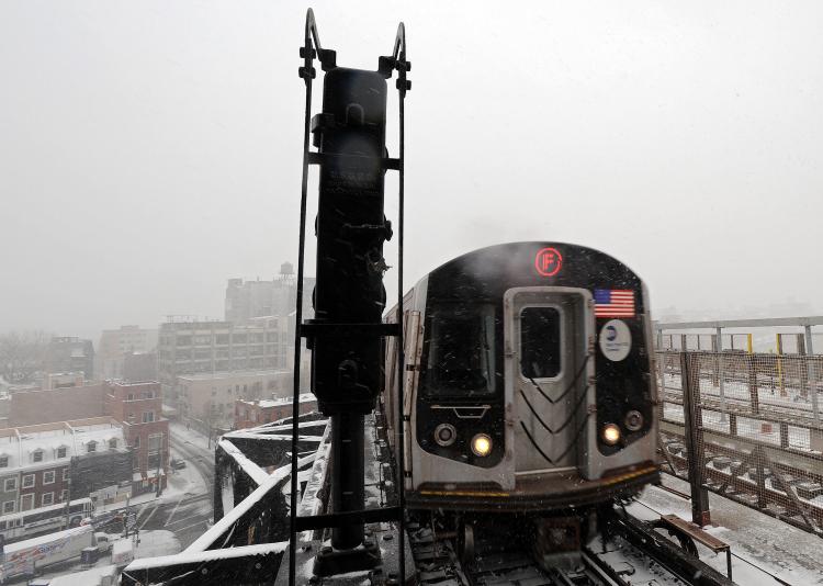 State of Emergency in Massachusetts, New Jersey, Delaware: The F-train pulls into the station at Smith and Ninth street on Dec. 26 in New York City. A winter storm is pounding the East Coast of the United States and is expected to deliver a foot of snow for New York City and New England while snarling post-Christmas travel. (Michael Heiman/Getty Images)