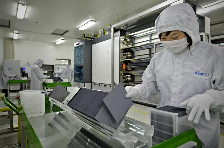 A masked scientist sorts silicon wafers at the manufacturing center of solar cell maker Trina Solar in Changzhou, China, in November 2009. Many global firms are currently outsourcing research and development to China. (Philippe Lopez/AFP/Getty Images)