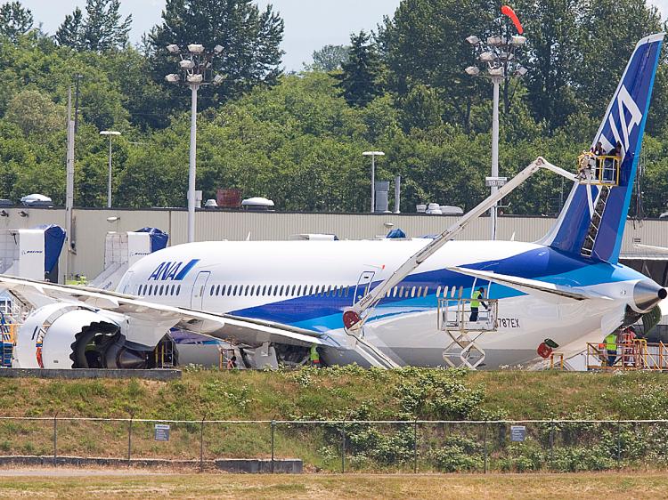 Workers in lifts tend to the exterior of one of two Boeing 787 Dreamliners sitting on the flight line near the company's production facilities at Paine Field in Everett, Washington. (Stephen Brashear/Getty Images)