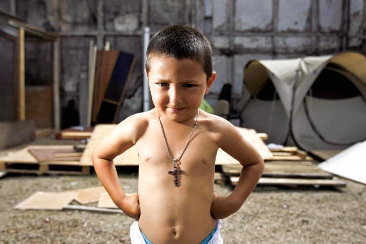 A young Roma boy stands in makeshift camp in Saint-Denis, outside Paris on Aug. 7. French President Nicolas Sarkozy began Thursday dismantling 300 camps of migrant and travelling peoples.  (Joel Saget/AFP/Getty Images)