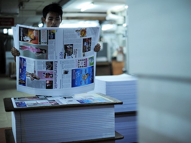 A print house worker checks sheets of a local journal in Rangoon