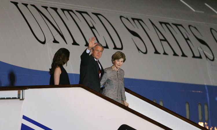 U.S. President George W. Bush (C) waves as First Lady Laura Bush (R) and daughter Barbara Bush walk down the steps from Air Force One after arriving August 7, 2008 in Beijing, China. Chinese authorities are anxious to publicize a list of about 80 foreign  (Andrew Wong/Getty Images)