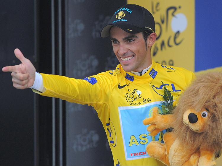 Alberto Contador gives his 'pistol shot' salute from the top step of the podium of Stage Eighteen of the 2009 Tour de France. (Patrick Hertzog/AFP/Getty Images)