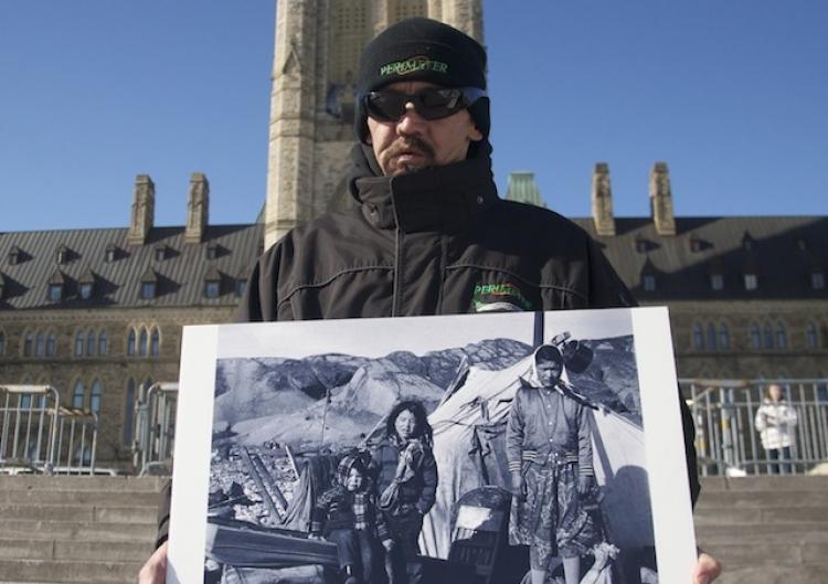 Lost Generation: A member of a delegation of Sayisi Dene holds a photograph of children standing on the shore of the Hudson Bay after the Sayisi Dene were forcefully relocated there 50 years ago. The delegation came to Ottawa Tuesday to ask the government (Matthew Little/The Epoch Times)