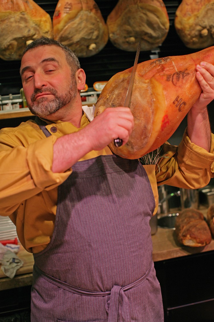 SIGNATURE BUNCH: Chef Casella wearing fragrant sprigs of rosemary, ready to cut into a Prosciutto di Parma. (Courtesy Salumeria Rosi Parmacotto)