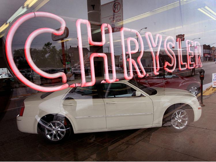 A neon sign shines in the showroom window of a Chrysler dealership in Chicago, Illinois which is scheduled to close today. (Scott Olson/Getty Images)