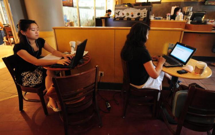 Women use their laptop computers at a wireless cafe in Beijing.  (Frederic J. Brown/AFP/Getty Images)