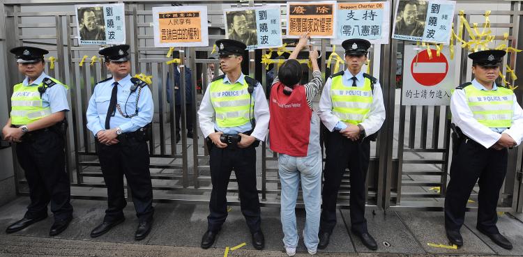 A woman puts a banner on the China liaison office in Hong Kong on Dec. 25 to protest over the sentencing of Chinese dissident Liu Xiaobo to 11 years in prison.  (Mike Clarke/AFP/Getty Images)