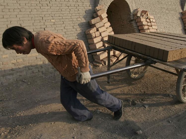 A worker removes half-made bricks at a brick factory in Huangzhong County of Qinghai Province, China. (China Photos/Getty Images)