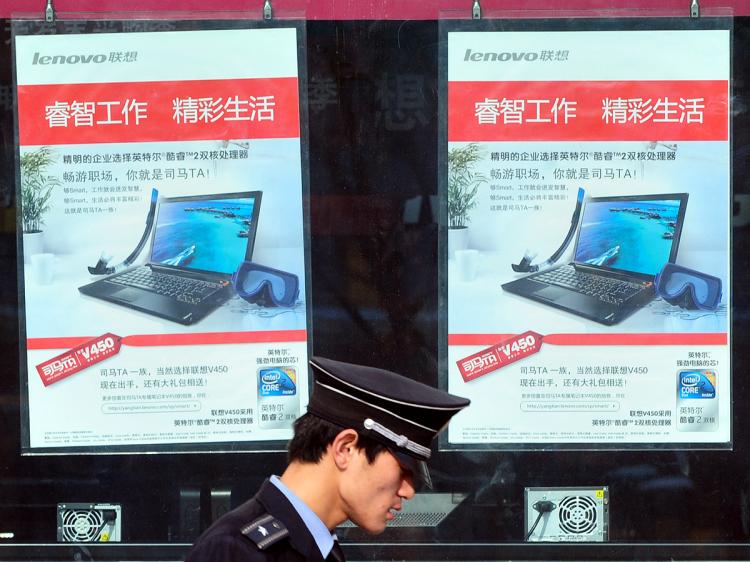 A computer mart security guard walks past advertising signs for laptop computers in Beijing on January 6, 2010. A California firm filed a 2.2 billion USD lawsuit against China on January 5, accusing Beijing of stealing its technology to bar Internet access to political and religious sites in China. (Frederic J. Brown/AFP/Getty Images)