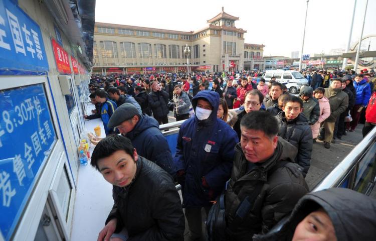 People wait in line to buy train tickets at Beijing Railway Station on January 22, 2011. The world's biggest annual migration of people is underway in China as millions of travellers across the country journey home for the Lunar New Year celebrations. (Frederic J. Brown/AFP/Getty Images)
