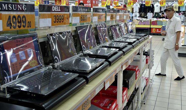 A man walks next to a row of laptops displayed at a supermarket in Beijing, June 10, 2009. (Liu Jin/AFP/Getty Images)
