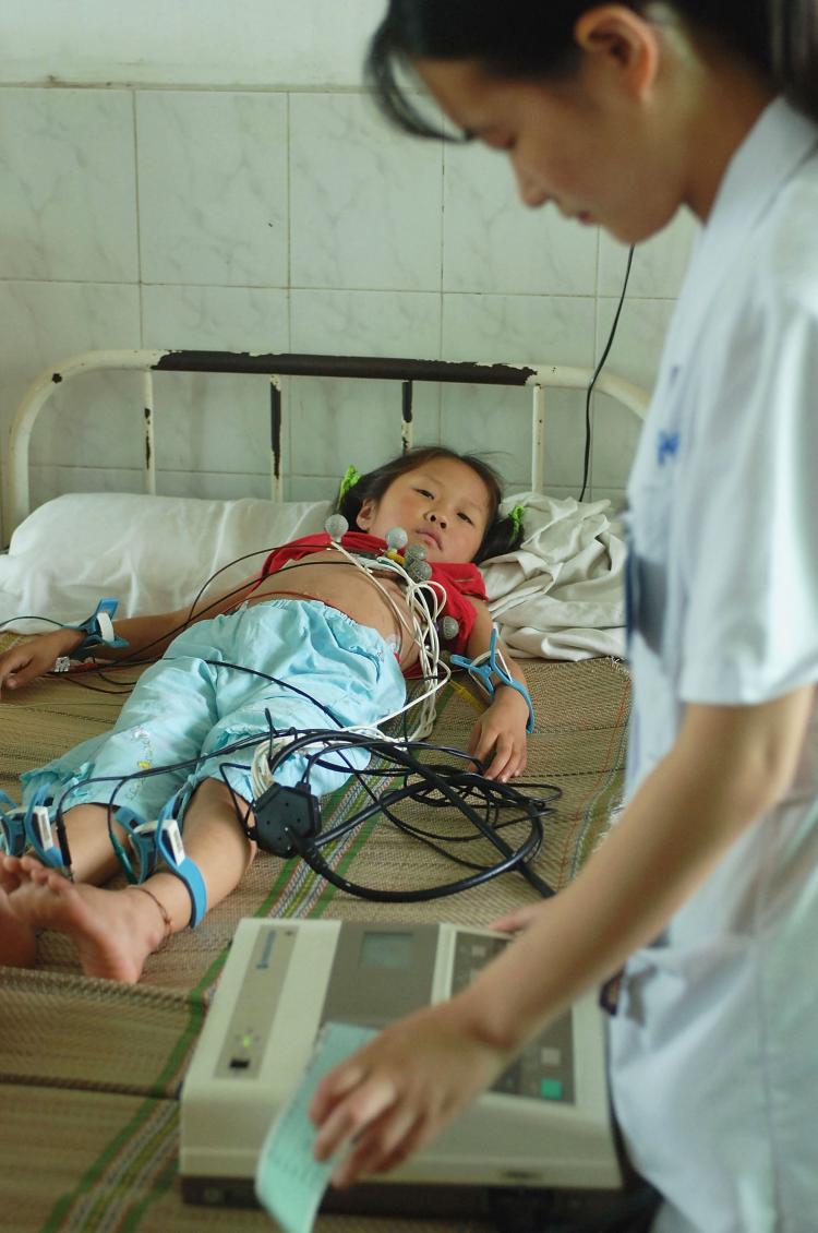 A nurse checks the cardiogram of a young girl sickened during a vaccine accident at a hospital in China.   (China Photos/Getty Images)