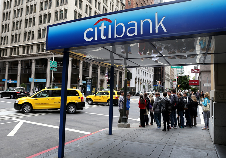 Pedestrians walk by a Citibank branch office on July 16 in San Francisco, Calif. 