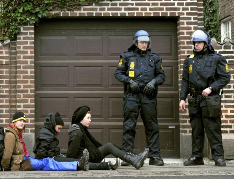 Police officers stand beside female protestors after they were restrained following an unauthorised demonstration in the northern section of Copenhagen on Dec. 13. The demonstration followed the mostly peaceful march on Dec. 1. Led by dancers and drummers, 30,000 people marched through Copenhagen, demanding world leaders declare war on the greenhouse gases that threaten future generations with hunger, poverty and homelessness. (Adrian Dennis/AFP/Getty Images)