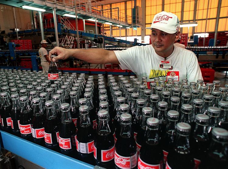 Coca-Cola on Wednesday said they are expanding their operations in the Philippines. Shown above, A worker inspects bottles of Coca-Cola in Coca-Cola's plant in Bacolod, Philippines. (Justin Sullivan/Getty Images)