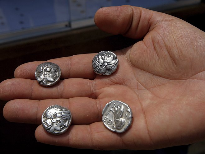 An archeologist holds silver Greek coins found at the Tal-Zorob site near the border with Egypt, in the southern Gaza Strip, May 2011. The Greeks made silver into coins 2500 years ago, and for the next 2400 years, silver was the primary currency in daily commerce, though it has fallen out of favor in recent times. (SAID KHATIB/AFP/Getty Images) 