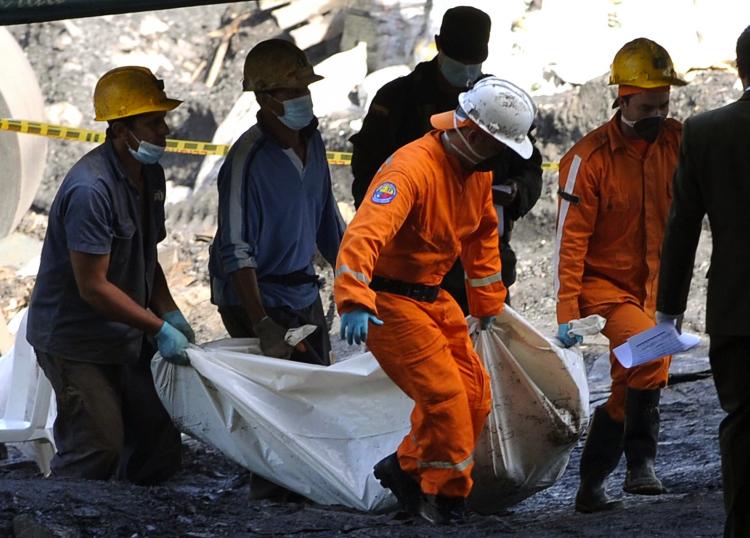 Colombian rescue workers and miners remove the bodies of victims after the explosion that ripped through a coal mine in the municipality of Amaga, Antioquia department, northeast Colombia on June 17, 2010.  (Raul Arboleda/AFP/Getty Images)
