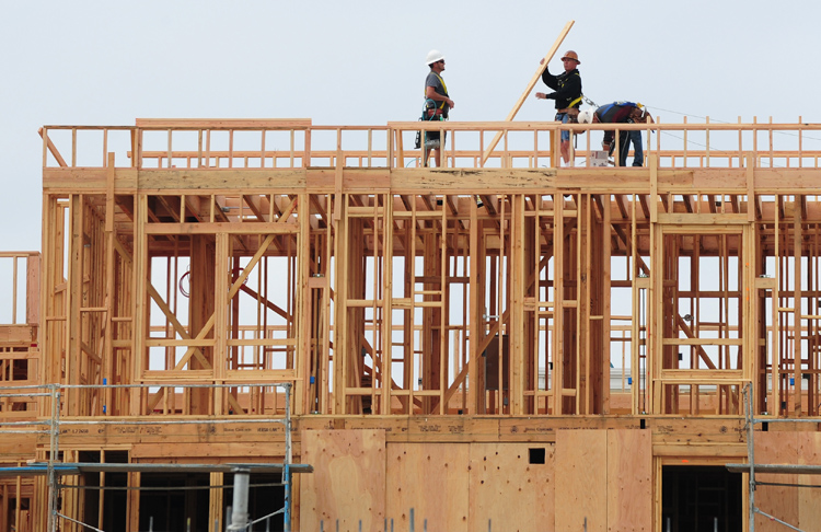 Construction workers are seen atop a bui