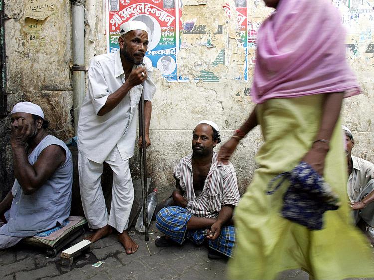 An Indian woman walks past beggars in New Delhi. (Christophe Archambault/AFP/Getty Images)